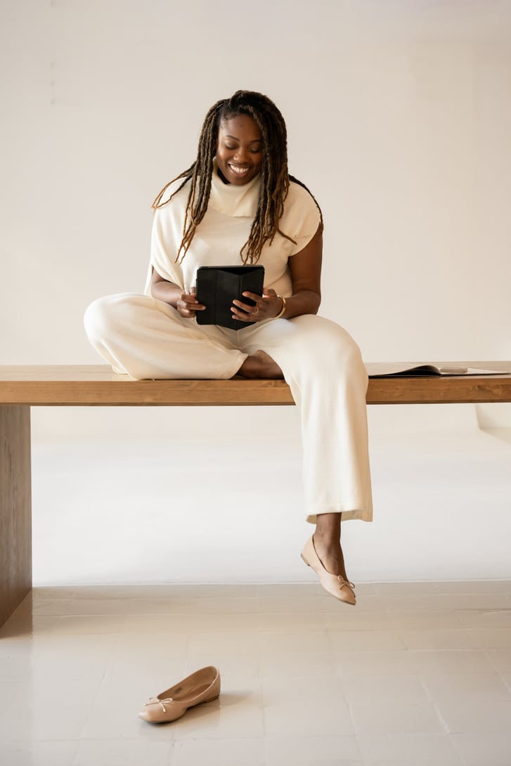 Elegant Office Business Woman Sitting on a Table with Tablet